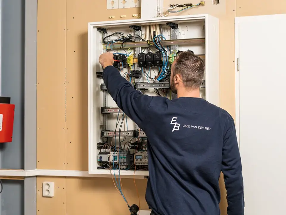 Man meet elektrotechnische apparatuur door