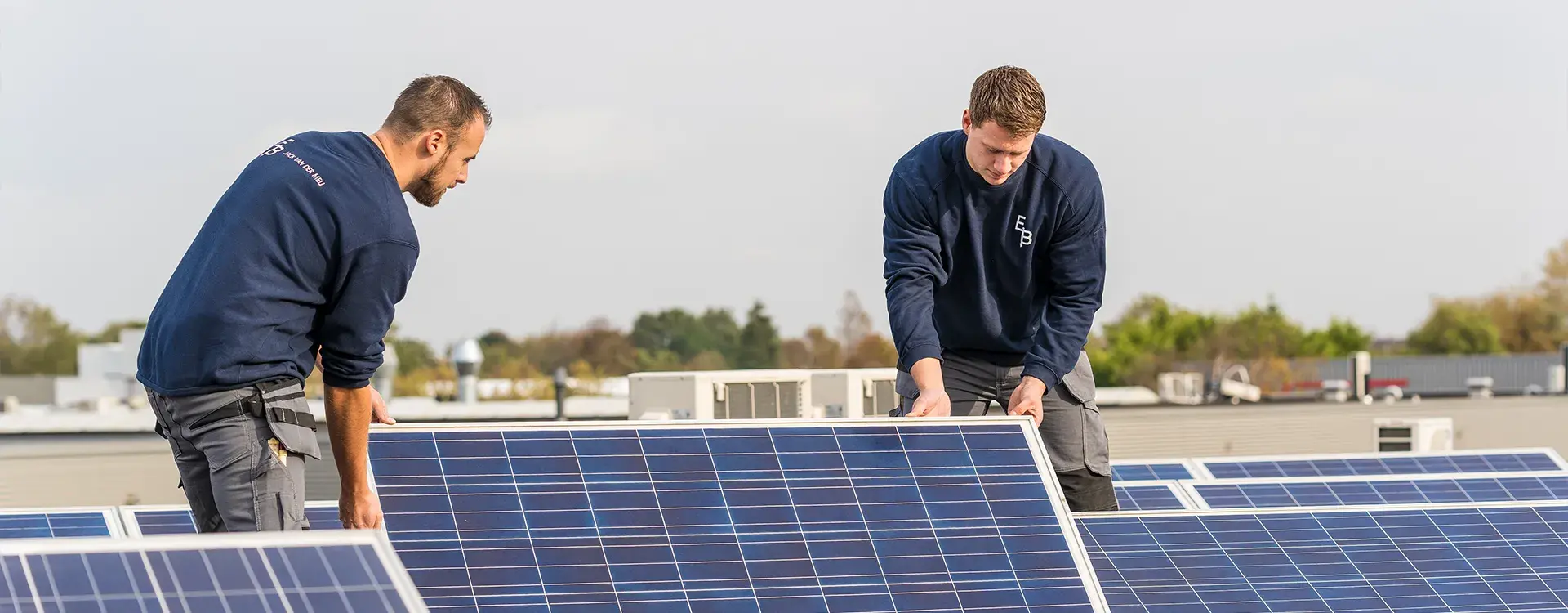 Verduurzamen voor bedrijven mannen op dak bezig met zonnepanelen header